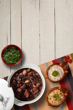 three bowls of food sitting on top of a striped place mat next to each other