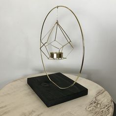 a metal object sitting on top of a table next to a wooden board and candle holder