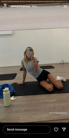 a woman taking a selfie while sitting on a yoga mat