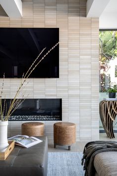 a living room filled with furniture and a flat screen tv mounted on the wall above a fireplace