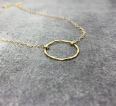 Gold Circle Necklace This dainty gold open circle necklace features a beautifully hammered circle delicately suspended from a strong, but dainty gold filled chain. The perfect minimalist necklace! Available in sterling silver or gold. -26mm gold filled hammered circle. -Dainty gold filled cable chain. - I do offer a gift wrapping option for gift giving purposes. GOLD-FILLED JEWELRY: - 14kt Gold filled offers an economical alternative to solid gold. - 14kt Gold filled jewelry is made by bonding a Dainty Jewelry With Delicate Open Circle Chain, Dainty Open Circle Jewelry With Delicate Chain, Dainty Hammered Circle Jewelry, Delicate Gold Open Circle Necklace, Puzzle Piece Necklace, Open Circle Necklace, Eternity Necklace, Gold Circle Necklace, Karma Necklace