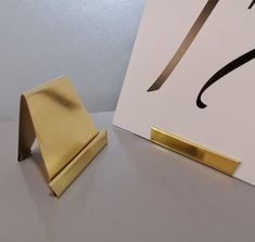 a pair of scissors sitting on top of a table next to a box with a gold handle