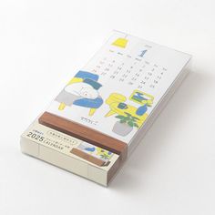 a calendar sitting on top of a desk next to a pen and paper holder with an image of a cat