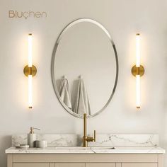 a bathroom vanity with two lights and a round mirror on the wall next to it