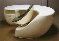 a white couch sitting on top of a hard wood floor next to a computer desk