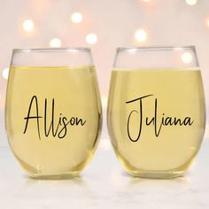 two wine glasses with names on them sitting next to each other