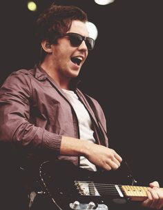 a man with sunglasses playing an electric guitar