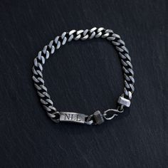 A personalized bracelet for men with an ID bar, that can be engraved, in oxidized sterling silver on curb chain and a unique handmade hook at closure. This custom men jewelry is 100% made by hand and it is an excellent choice for a birthday gift for him. D E T A I L S * Metal: High Quality Sterling Silver 925 * Finish: Black Oxidized * Curb Chain 7mm * Tag Dimensions: 20mm x 8mm * Length: 7.5 inches - 9 inches * You can personalize it if you want to 100% nickel free. Delivered in an elegant gift Classic Engraved Cuban Link Jewelry, Classic Engraved Stainless Steel Bracelet, Classic Stainless Steel Engraved Bracelet, Engraved Cuban Link Bracelets As Gift, Antique Silver Engraved Bracelets For Anniversary, Silver Minimalist Chain Bracelet With Engraving, Engraved Antique Silver Bracelets For Anniversary, Silver Minimalist Engraved Chain Bracelet, Classic Engraved Sterling Silver Chain Bracelet