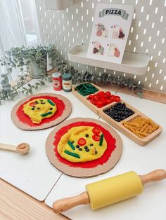 three pizzas with different toppings on them sitting on a table next to a rolling pin