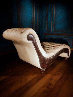 a white chair sitting on top of a hard wood floor next to a blue wall