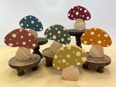 several wooden mushrooms with polka dots on them sitting on top of each other in front of a white background