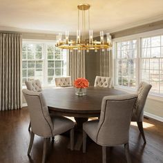 a dinning room table with chairs and a chandelier