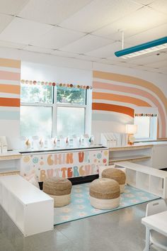 an empty room with two stools in front of the counter and colorful wallpaper on the walls