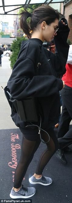 a woman in black jacket and leggings with headphones