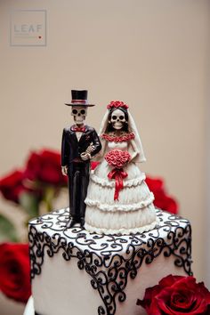 a wedding cake with a skeleton bride and groom on top