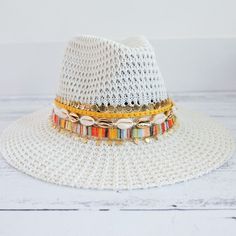 This hat is a total vibe. one of my favorites to keep the sun away and look fab while your doing it.  This hat is one size fits most and comes with an inner drawstring to make the hat smaller if need be.   All hats come customized like in the picture but you do have the option to choose what color trim you would like above the row of shells. Casual White Hat Band For The Beach, Casual White Hat Band For Beach, White Summer Hat Bands For Vacation, White Beach Fedora (one Size Fits Most), Multicolor Flat Brim Fedora For Summer, White Brimmed Fedora For Festival, White Fedora Hat For Festival, White Fedora For Beach, One Size Fits Most, Multicolor Summer Fedora For Vacation