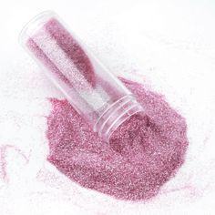 a jar filled with pink glitter sitting on top of a white surface