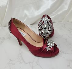 Stunning Burgundy Wedding Shoes with a sparkling crystal front and back design. These beautiful satin shoes are approximately 3 1/2 inches. They have a slight platform of 1/4th inches. The listing picture shows the shoes in Burgundy but is available in white, ivory and navy as well. Please email me with any questions you may have! Please visit my website for additional bridal products. http://www.abiddabling.com IMPORTANT ALL SIZES ARE IN U.S. SIZES - PLEASE CONTACT ME IF YOU NEED ASSISTANCE IN Red Quinceanera Shoes High Heels, Crystal Embellished Open Toe Wedding Shoes For Reception, Crystal-embellished Open Toe Wedding Shoes For Reception, Glamorous Rhinestone Wedding Shoes For Reception, Open Toe Wedding Shoes With Rhinestones For Reception, Closed Toe Heels With Rhinestones For Receptions, Crystal Embellished Heels For Wedding Reception, Formal Wedding Shoes With Rhinestones, Closed Toe, Formal Wedding Shoes With Rhinestones