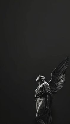 an angel statue is standing in the dark