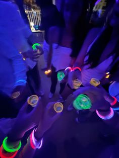 many people are holding their hands together with glowing lights on them and cups in the middle