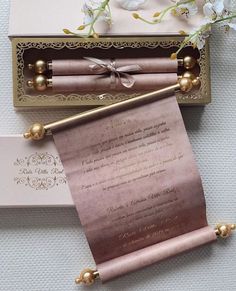 the wedding stationery is set up in a box with gold trimmings and ribbon