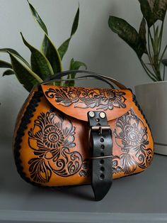 Traditional Leather Saddle Bag, Traditional Hand Tooled Saddle Bag, Artisan Hand Tooled Saddle Satchel Bag, Traditional Handmade Leather Saddle Bag, Traditional Leather Shoulder Bag With Embossed Detail, Artisan Hand Tooled Leather Saddle Bag, Traditional Leather Embossed Bags, Artisan Hand-tooled Leather Saddle Bag, Artisan Leather Bag With Engraving