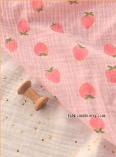 the fabric has strawberrys on it and is pink with gold flecks, as well as a wooden button