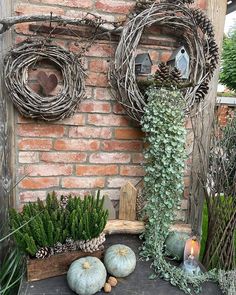 a brick wall with wreaths and plants on it