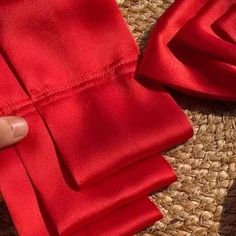 a person is holding onto some red cloth