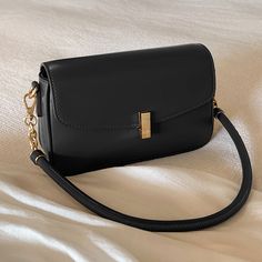 A shoulder bag with a square body and a flap that can hold a smartphone and a small wallet. The golden clasp and small design give it an elegant and stylish impression. It is also possible to remove the shoulder strap. 
 
 
 Color 
 
 Dark brown 
 Black 
 
 
 Size 
 
 
 FREE size 
 
 Height: 14cm 
 Width: 22cm 
 Depth: 6.5cm 
 
 
 
 
 
 Material 
 
 Leather Classic Gold Shoulder Bag With Hasp Closure, Chic Square Phone Bag For Travel, Elegant Gold Satchel With Hasp Closure, Rectangular Baguette Bag With Hasp Closure, Square Flap Bag With Hasp Closure For Daily Use, Rectangular Phone Bag With Detachable Strap, Classic Rectangular Flap Bag With Chain Strap, Rectangular Phone Bag With Chain Strap, Everyday Rectangular Flap Bag With Gold-tone Hardware