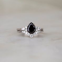 a black and white diamond ring sitting on top of a table