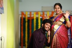 a man standing next to a woman in a red and gold sari