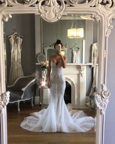 a woman is taking a selfie in front of a mirror wearing a wedding dress