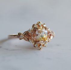 a fancy engagement ring with an orange and white diamond