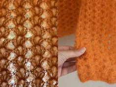 someone is holding the edge of an orange crochet shawl with their hand