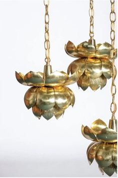 two chandeliers hanging from chains with gold colored flowers and leaves on the bottom