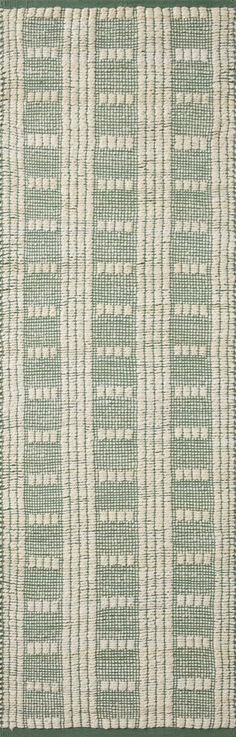 a green and white striped rug with fringes