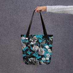 Make a statement with our stunning floral tote bag, perfect for carrying your essentials in style.  The vibrant floral print adds a pop of color to any outfit, while the sturdy canvas material ensures durability and longevity. With plenty of room to store your everyday items, this spacious tote features both interior and exterior pockets for easy organization.  The comfortable shoulder straps make it easy to carry, whether you're running errands or heading to the beach. Versatile and chic, this floral tote is the perfect accessory for any fashion-forward individual. Order now and elevate your daily look with our beautiful floral tote bag. * 100% spun polyester fabric * Bag size: 15″ × 15″ (38.1 × 38.1 cm) * Capacity: 2.6 US gal (10 l) * Maximum weight limit: 44lbs (20 kg) * Dual handles ma Floral Print Canvas Tote Bag For Everyday Use, Floral Print Canvas Tote Bag For Daily Use, Everyday Floral Print Canvas Tote Bag, Floral Print Canvas Tote Shoulder Bag, Black Floral Print Tote Bag, Trendy Cotton Bags With Floral Print, Multicolor Floral Print Canvas Bag For Everyday, Casual Rectangular Canvas Bag With Floral Print, Everyday Black Bag With Floral Print