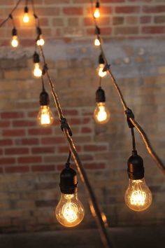 some light bulbs are hanging from a brick wall