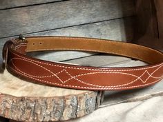 Our beautiful hand-crafted Western stitched English Bridle Vegetable-tanned leather belts that we line with a beautiful tan suede giving this belt durability and strength, yet still making it flexible for comfort. The thickness (13oz.) of this belt is perfect for carrying a gun or other accessories that attach to your belt, or if you prefer to wear for the high end appearance this gives any attire. **COLOR PREFERENCE -Golden Brown -Buck Brown -Rich Brown -Havana **BUCKLE PREFERENCE -Antique Nick Everyday Bridle Leather Belts And Suspenders With Removable Belt, Bridle Leather Belts And Suspenders For Everyday Use, Classic Adjustable Embroidered Belt, Adjustable Embroidered Leather Belt, Fitted Leather Belts And Suspenders, Western Belts With Belt Loops For Everyday Use, Leather Western Belts For Everyday, Concealed Carry Belt, Belt Western