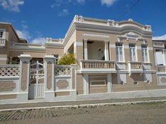 a large house with white trim on the front and side walls, along with two balconies