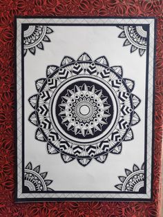 a red and white wall hanging with an intricate design