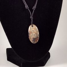 The Crazy Lace Agate pendant is approximately 1.4 inches in length on natural black polished round leather. The necklace is adjustable from 16 inches to 32 inches by sliding the knots. Agate is a rock consisting primarily of cryptocrystalline silica, chiefly chalcedony, alternating with microgranular quartz. It is characterized by its fineness of grain and variety of color. Although agates may be found in various kinds of host rock, they are classically associated with volcanic rocks and can be Adjustable Black Earthy Jewelry, Adjustable Oval Pendant Necklace, Artisan Adjustable Necklace With Oval Pendant, Earthy Adjustable Round Pendant Necklace, Adjustable Necklace With Oval Pendant And Natural Stones, Adjustable Oval Pendant Necklace With Natural Stones, Sterling Silver Earrings Handmade, Jasper Earrings, Black Polish