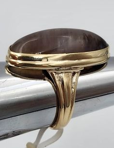 This is a 14k yellow gold ring set with a 26mm by 12mm oval smoky quartz. The ring is a size 6 and weighs 5.5 dwt. The quartz has color and pattern variations that did not show up very well in the pictures. Classic Oval Brown Ring, Classic Brown Oval Ring, Brown Oval Gemstone Rings, Classic Smoky Quartz Rings For Formal Occasions, Classic Formal Smoky Quartz Rings, Luxury Brown Oval Rings, Brown Oval Cabochon Rings, Formal Brown Cabochon Rings, Smoky Quartz Ring