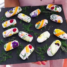 a person holding a black tray with different types of food items on top of it