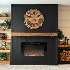 a fireplace with a clock on the wall above it and shelves filled with wood logs