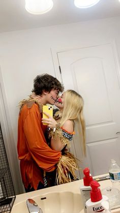 a man and woman kissing in front of a bathroom mirror