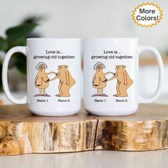 two coffee mugs sitting on top of a wooden table with the words love is growing old together