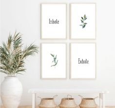 three framed art prints on the wall above a table with baskets and a potted plant