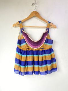 Vintage Miu Miu Striped Silk Top. Very delicate and so cute for summer! Features tan and blue stripes throughout with a purple and white cotton applique across the chest. Snap closures along the side. 100% silk, made in Italy. Marked a size 40, would best fit XS/S. In overall great vintage condition with some wear along the bust seam, refer to photos for more info. Approx. Measurements: Underarm to Underarm: 16" Length: 21" Summer Beach Top With Vertical Stripes, Vintage Miu Miu, Electric Feathers, Ryan Roche, Ace And Jig, Black Crane, Stripe Silk, Purple And White, Ulla Johnson